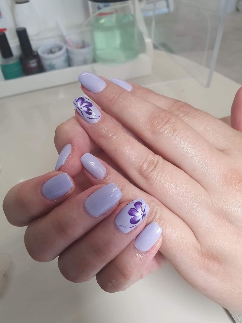 Fliederfarbene Nägel mit gemalter lila Blume als Nail Art