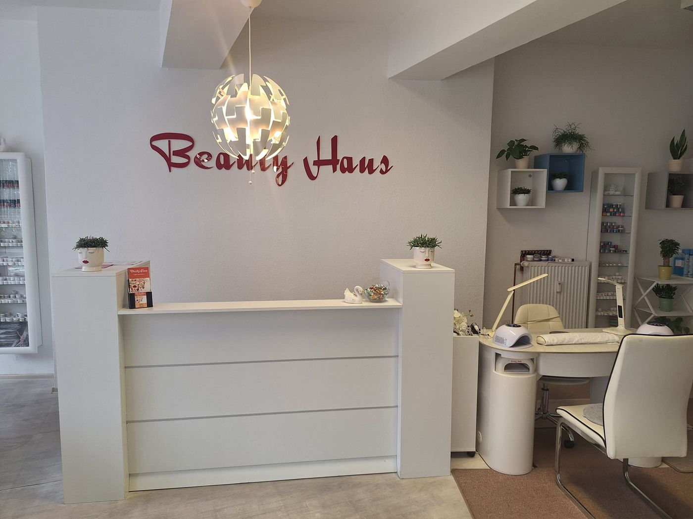 Empfangstresen mit dem Schriftzug Beauty Haus an der Wand